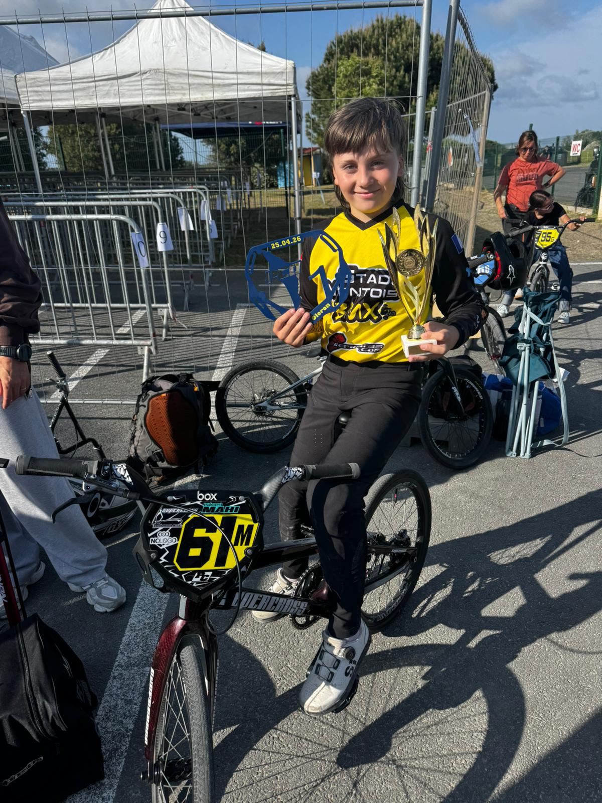 Kéoni MAHI assis sur son vélo BMX avec trophée